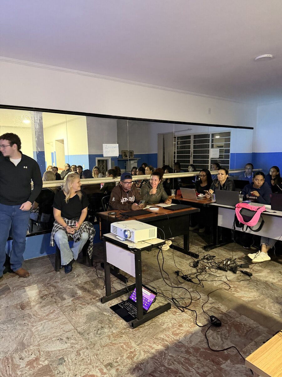 Sala do curso com projetor e alunos nas mesas